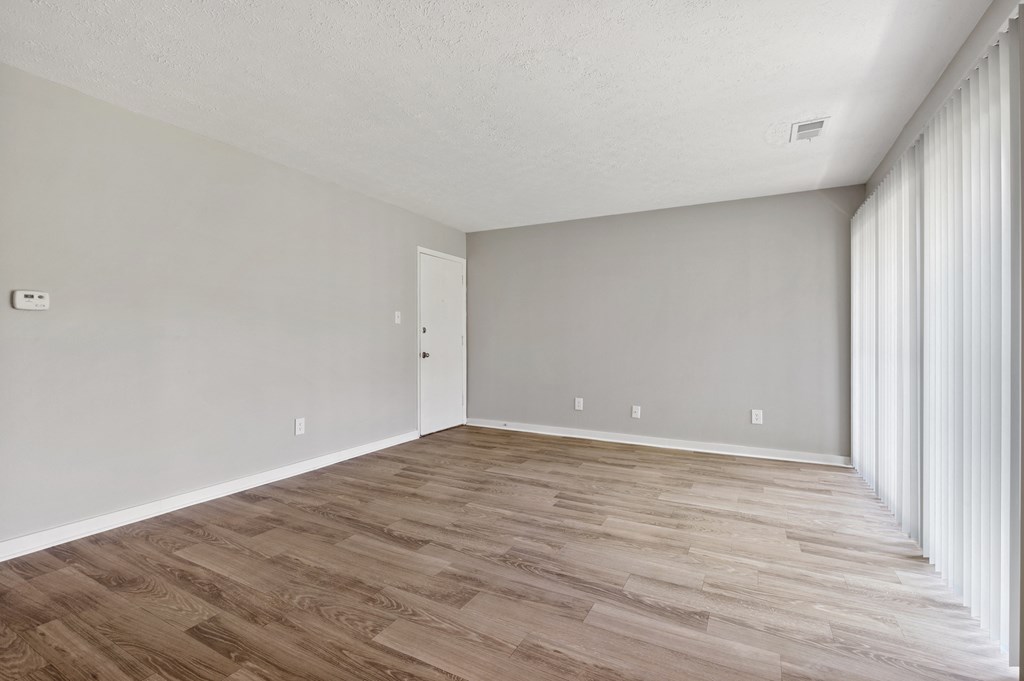 A room with wooden flooring and white walls.