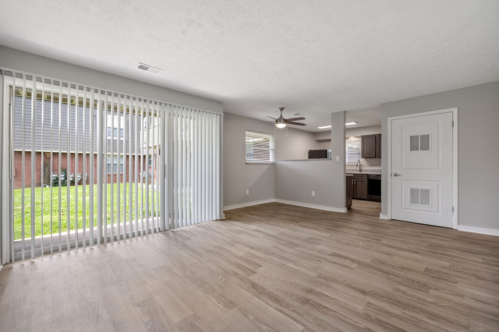 A room with a sliding glass door leading to a backyard.
