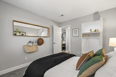 A bedroom with a large bed and a mirror on the wall.