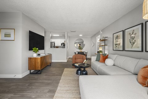 A living room with a white couch and a wooden side table.
