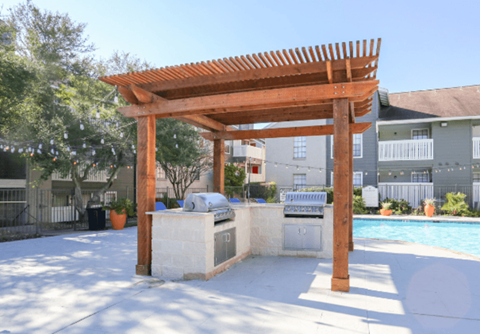 A wooden pergola stands over a pool area.