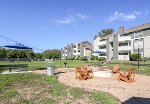 A sunny day at the park with chairs and a swing set.