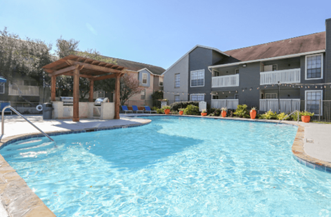 A swimming pool in front of apartment buildings.