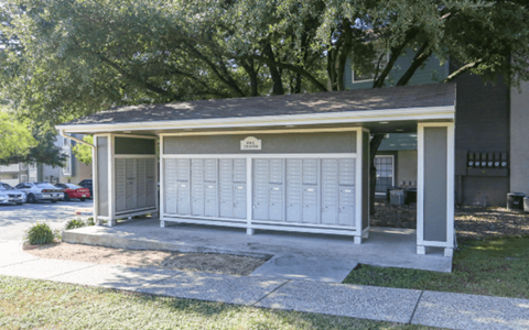 A small white building with a porch and a sign above the door.