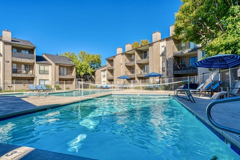A swimming pool in front of apartment buildings.