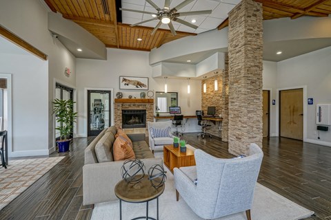 A living room with a grey couch, a wooden coffee table, and a stone pillar.
