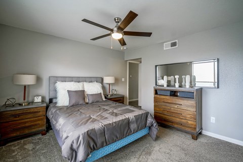 A bedroom with a bed, dresser, and mirror.