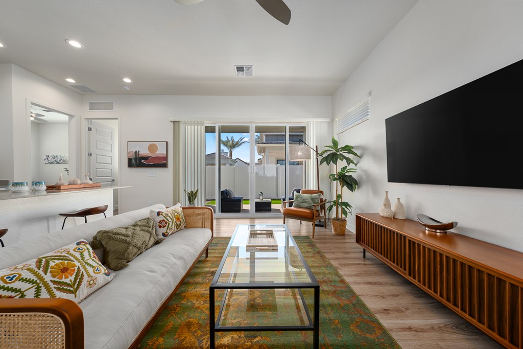 A living room with a white couch and a glass coffee table.