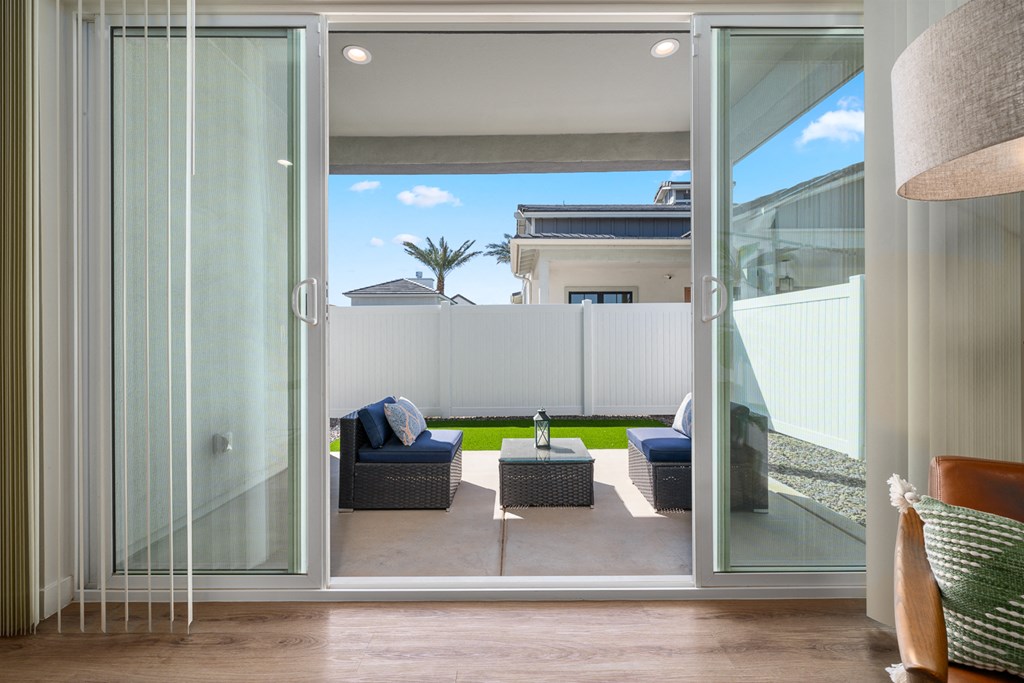 A modern living room with a glass door leading to a patio.