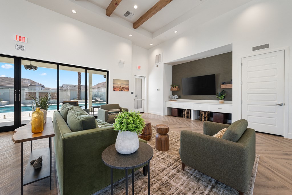A living room with a couch, chairs, and a television.
