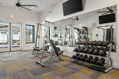 A gym with a variety of equipment including weights and machines.