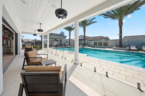 A patio with a pool and chairs.