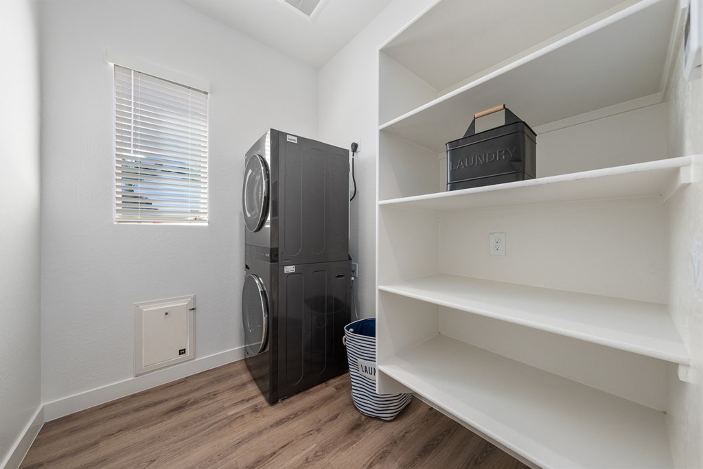 A black refrigerator sits in a kitchen next to a window.