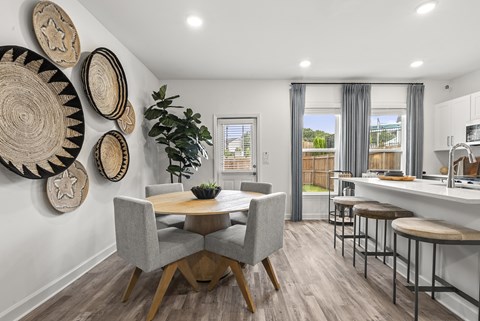A dining room with a table and chairs and a wall hanging of baskets.