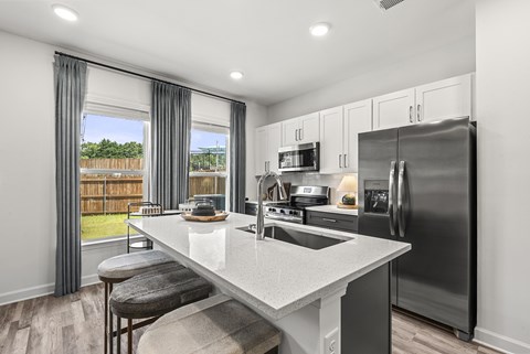 A modern kitchen with a large island and stainless steel appliances.