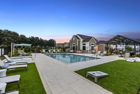 A backyard with a pool and lounge chairs.