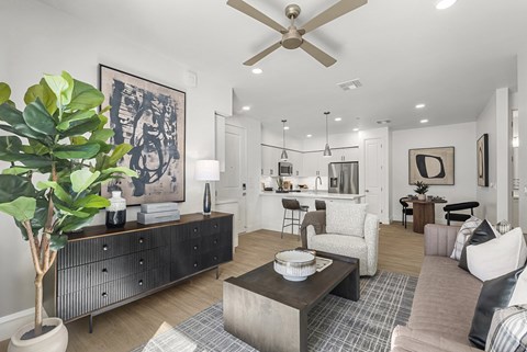 A living room with a ceiling fan and a large painting on the wall.