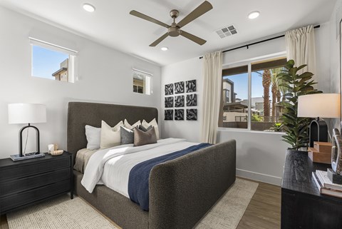 A bedroom with a large bed and a ceiling fan.