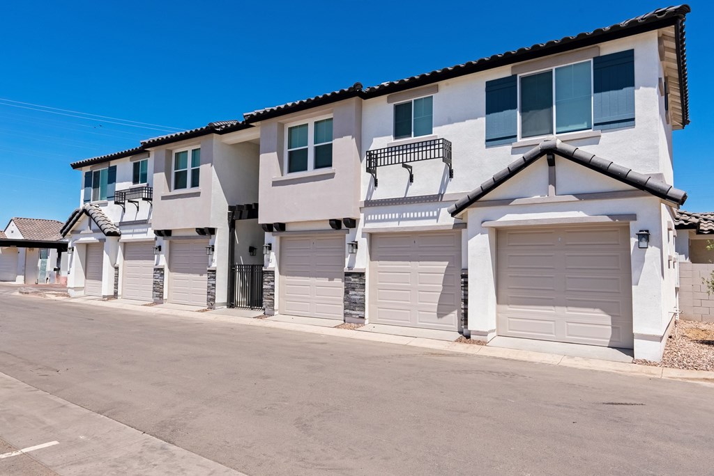 A row of houses with white garage doors.