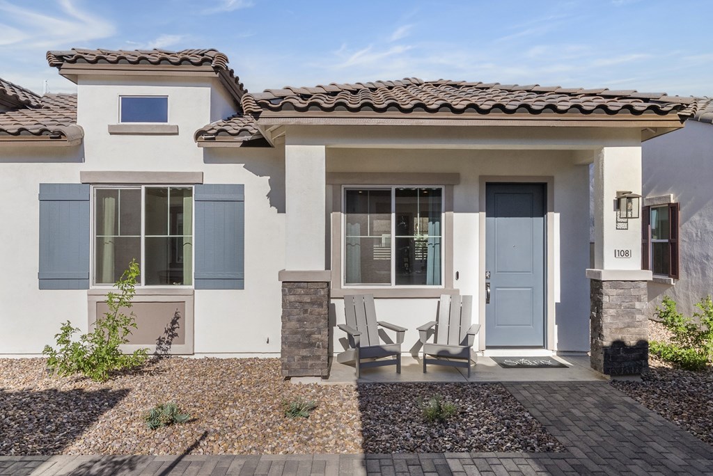 A modern house with a blue door and a small garden in front.