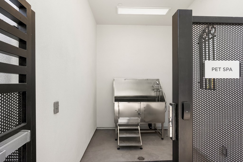 A pet spa sign is on a door with a metal grate.