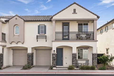 A two-story house with a balcony on the second floor.