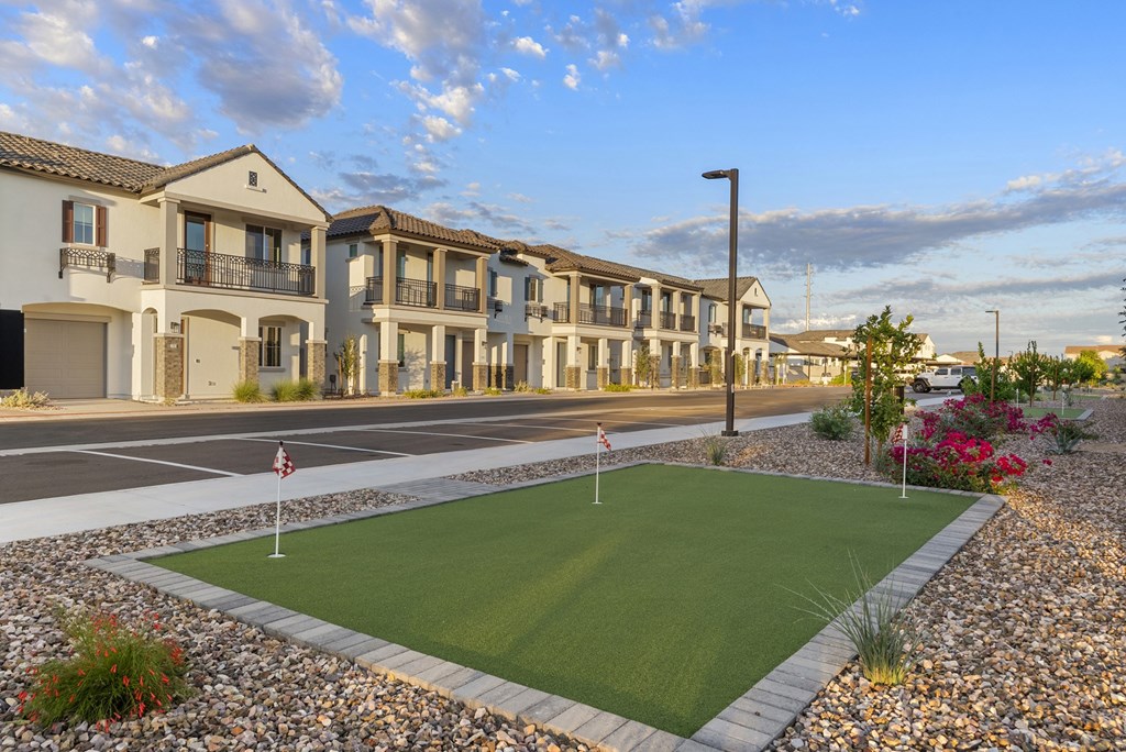 A row of houses with a green lawn in front.