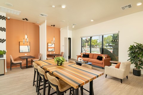 A modern dining room with a long wooden table and chairs.
