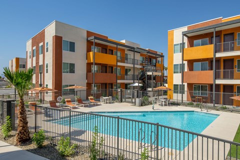 A large apartment complex with a pool in the courtyard.