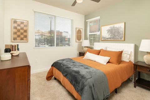 A bedroom with a bed, nightstand, and window.