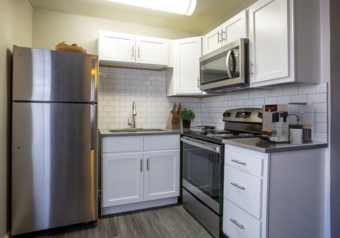 a kitchen with stainless steel appliances and white cabinets