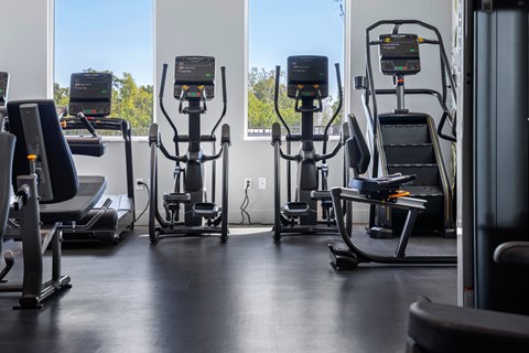 A gym with treadmills and elliptical machines.