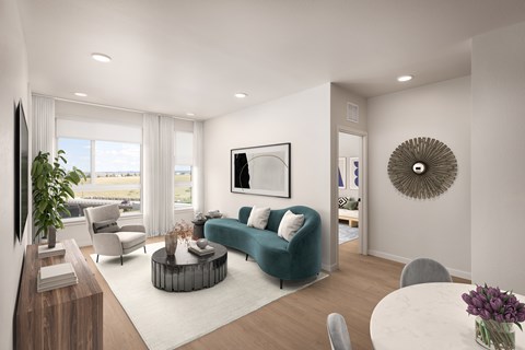 A modern living room with a green sofa and a large window.
