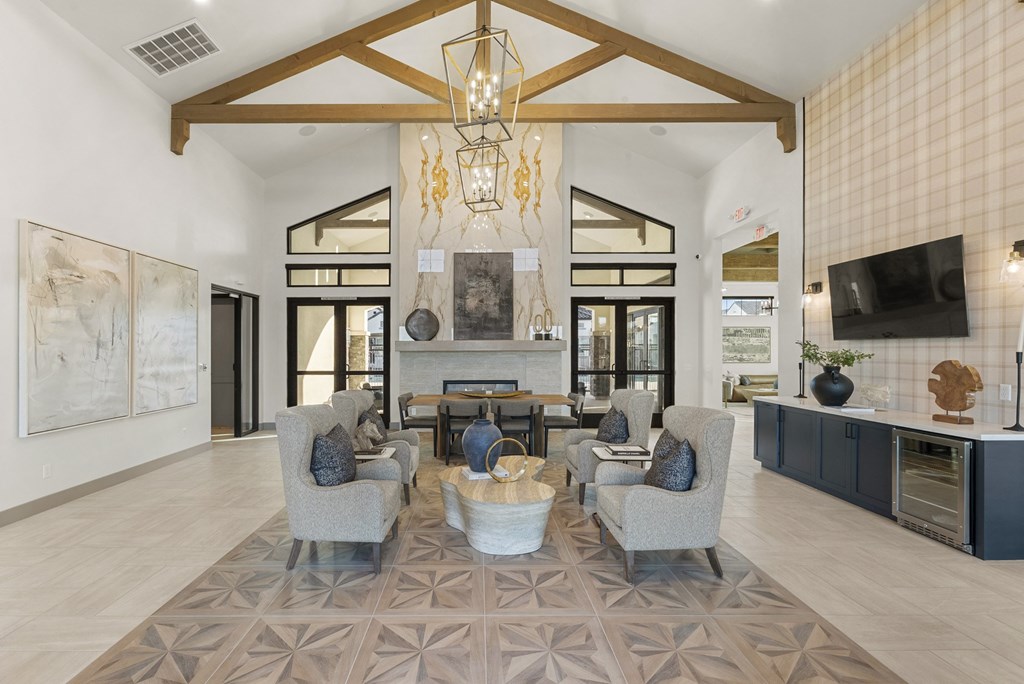 A modern living room with a large rug and a chandelier.