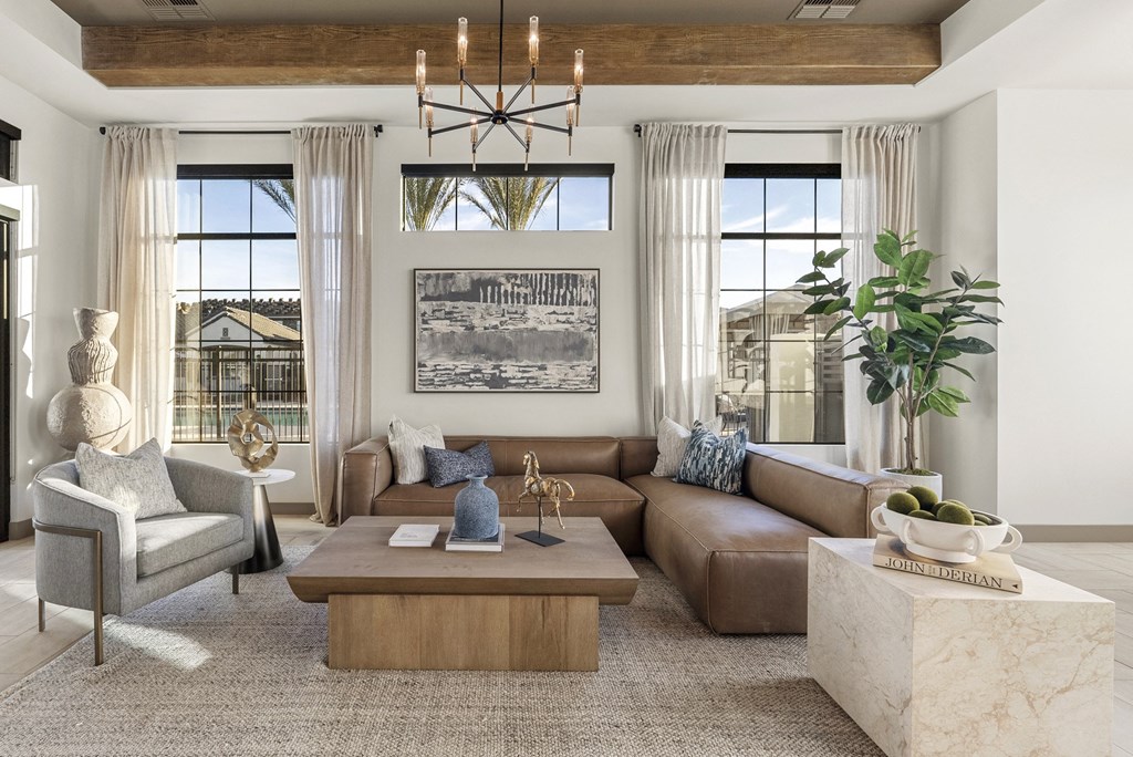 A living room with a large couch, a coffee table, and a chandelier.