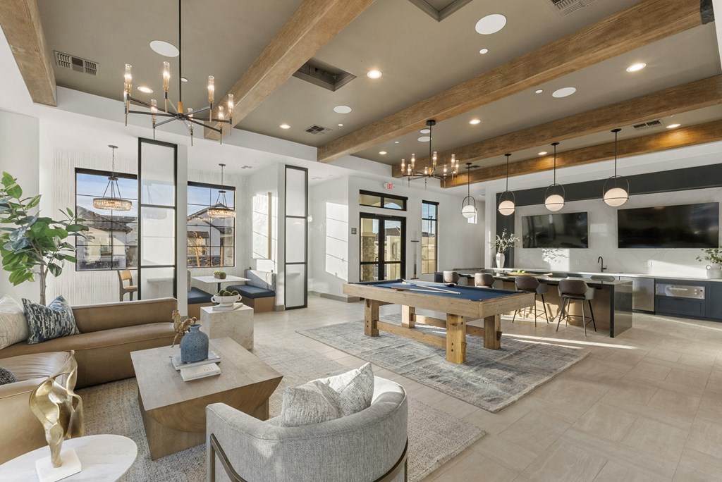 A modern living room with a large couch, a coffee table, and a TV.