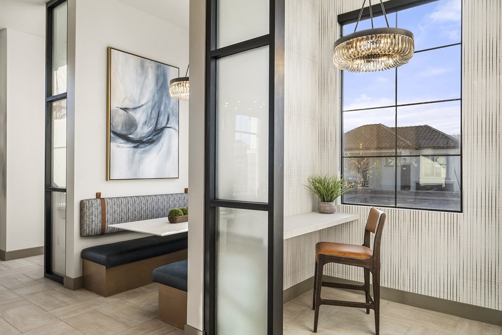 A room with a bench, a table, and a chair.