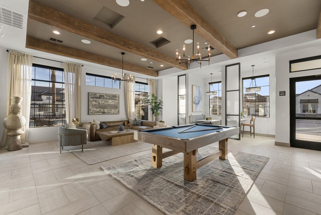 A large, well-lit room with a pool table and comfortable seating.