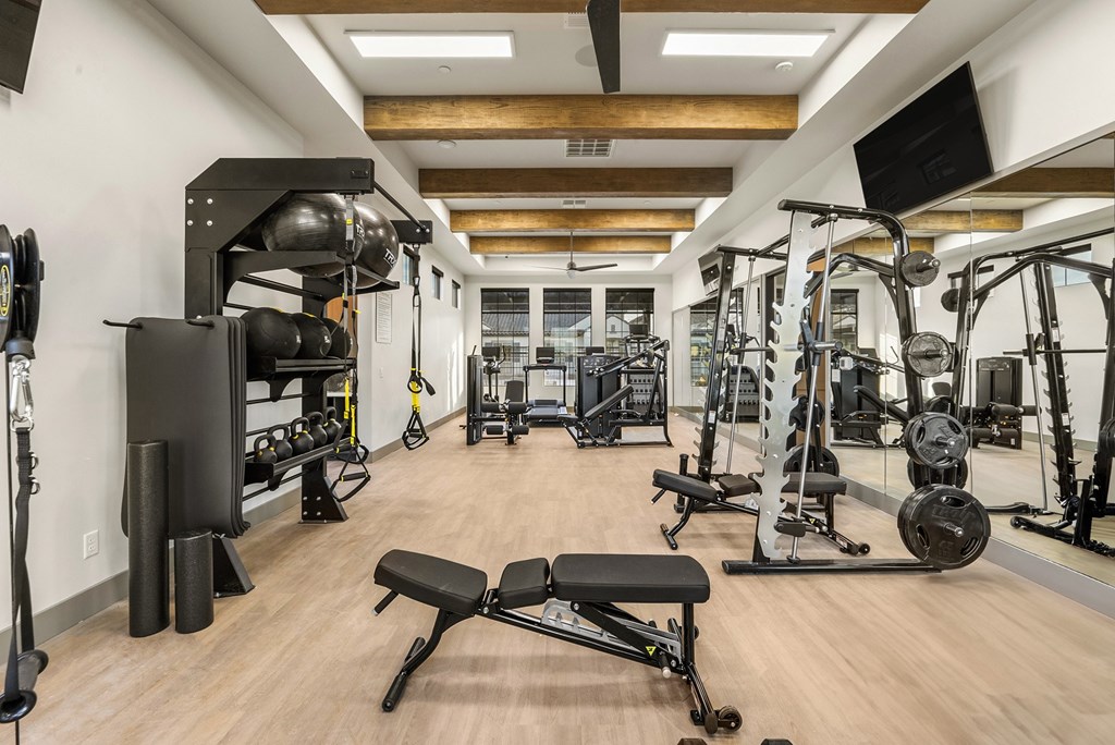 A gym with a variety of equipment including weights and machines.