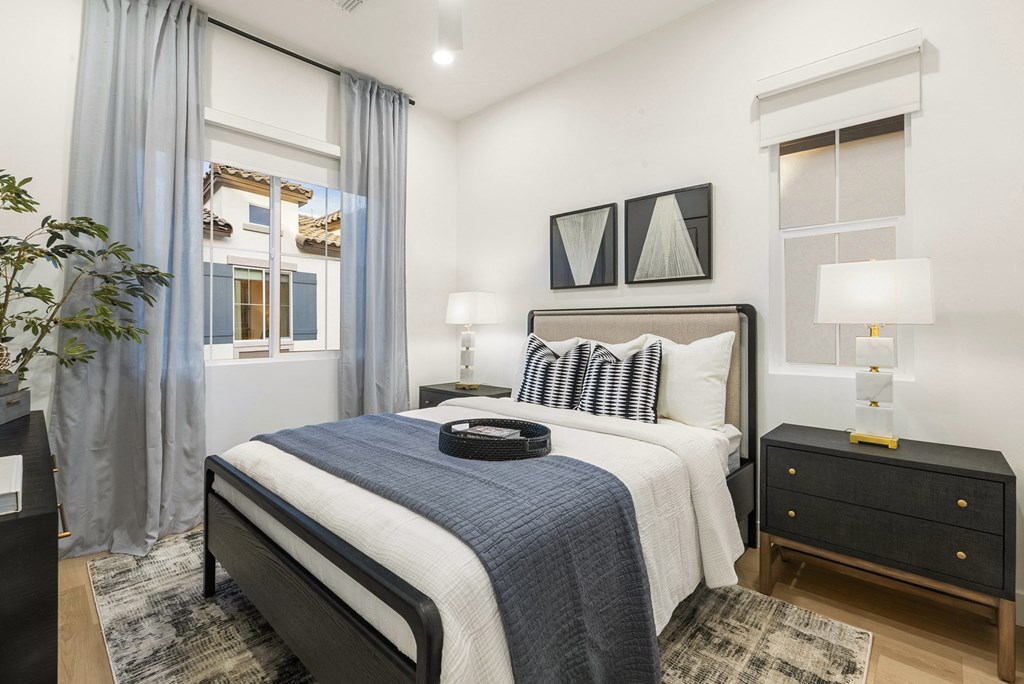 A bedroom with a large bed and a nightstand with a lamp.