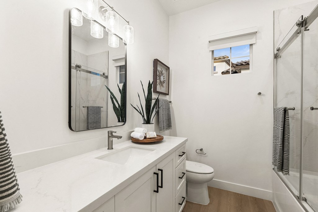 A bathroom with a white counter top and a toilet.
