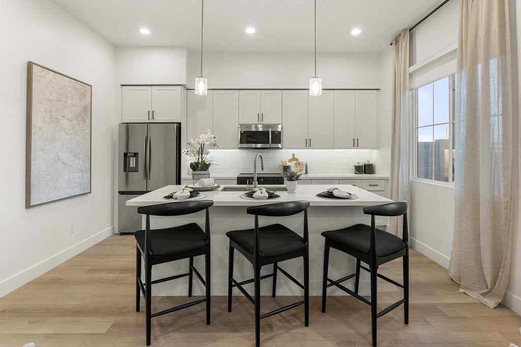 A modern kitchen with a dining table and chairs.