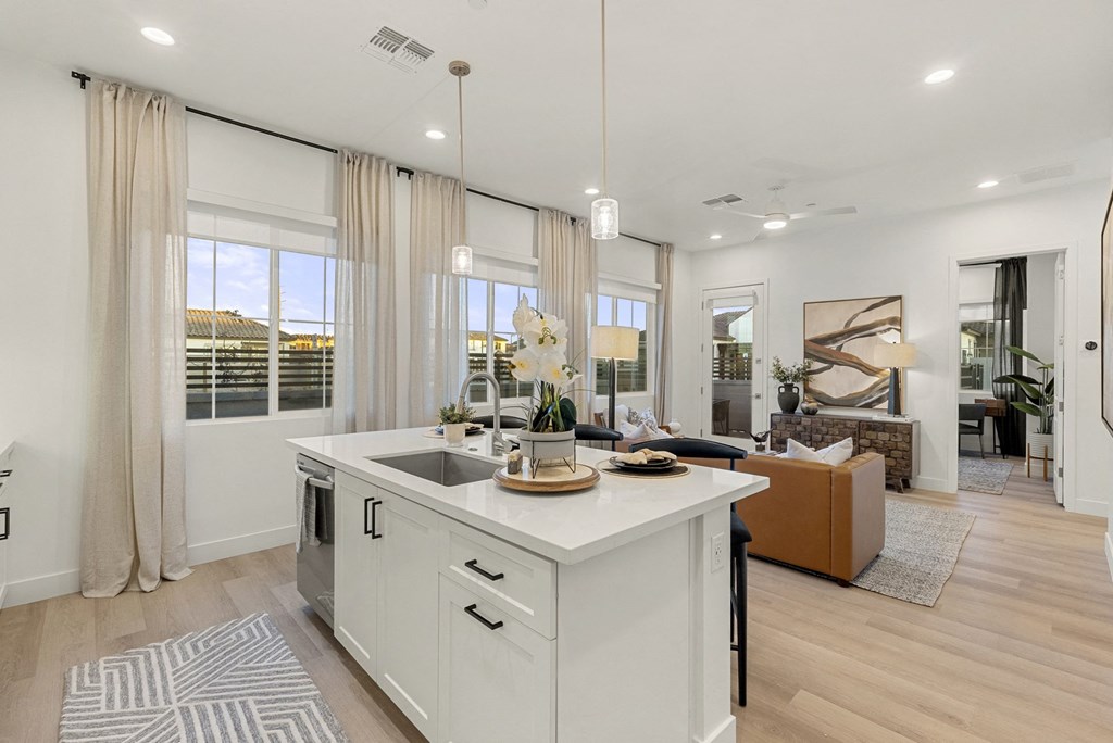 A modern kitchen with a large island and a view of the outdoors.