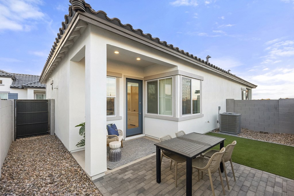 A small white house with a patio and a table.