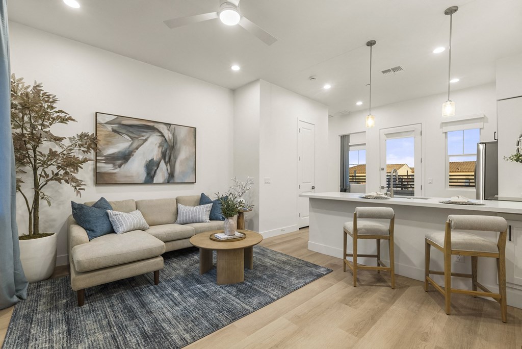 A living room with a couch, a table, and a painting on the wall.