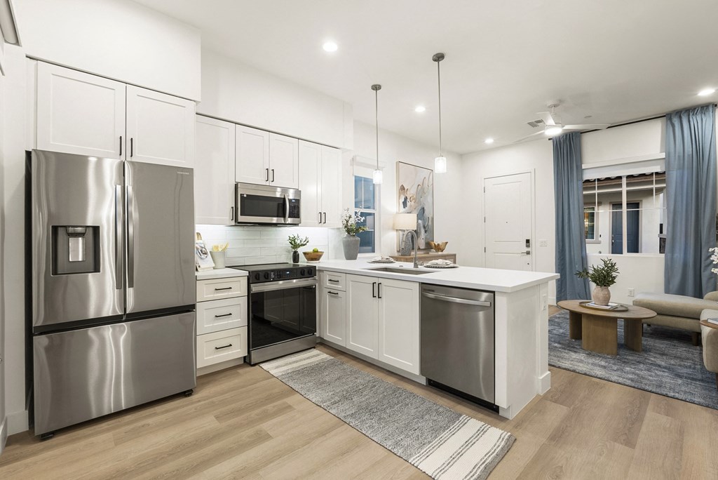 A modern kitchen with stainless steel appliances and white cabinetry.