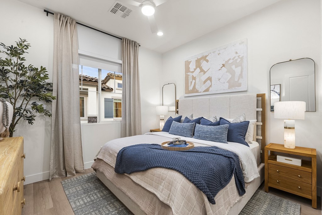 A bedroom with a large bed and a mirror on the wall.