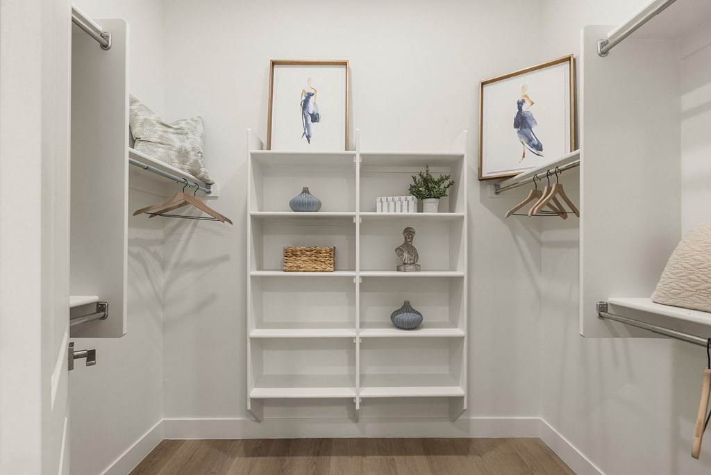 A white shelving unit with decorative items and two framed pictures on the wall.