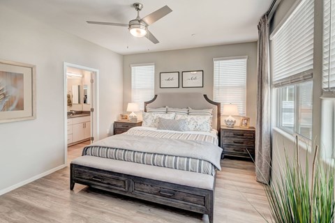 A bedroom with a large bed and a ceiling fan.
