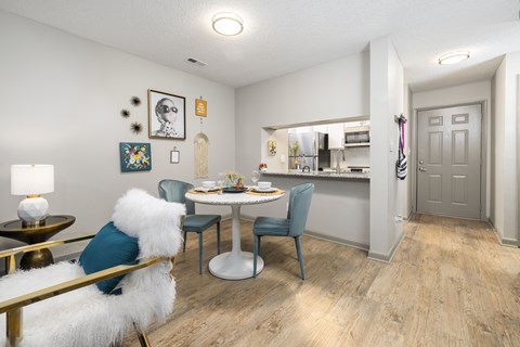 A dining area with a white table and chairs.